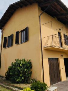 a yellow house with a balcony and a cactus at Civico 32 in Mondovì