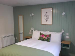 a bedroom with a bed with white sheets and flowers at Garden House Rooms in Kirkwall