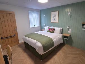 a bedroom with a bed with a green wall at Garden House Rooms in Kirkwall +13 photos