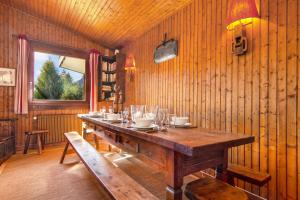 a dining room with a wooden table and a window at Chalet Dava La Via ski in - ski out - Happy Rentals in Chamonix