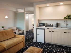 a living room with a couch and a kitchen at Colony House Motor Lodge in Roanoke