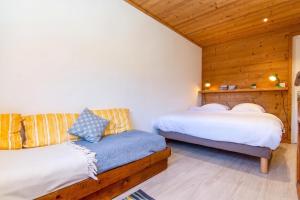 two beds in a room with wooden walls at Chalet Dava La Via ski in - ski out - Happy Rentals in Chamonix