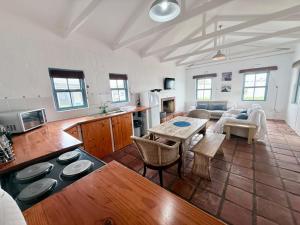 a large kitchen and living room with a table at Coast Cottages Langebaan in Langebaan