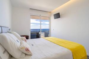 a bedroom with a large bed with a view of the ocean at Monumental Apartments - Multi Listing in Funchal