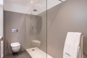 a bathroom with a toilet and a glass shower at Monumental Apartments - Multi Listing in Funchal +7 photos