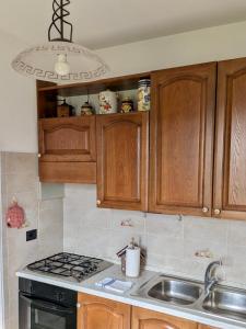 a kitchen with wooden cabinets and a sink and a chandelier at Civico 32 in Mondovì +12 photos