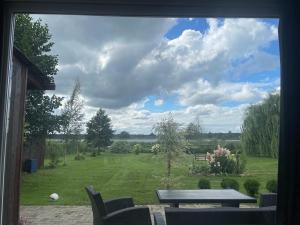 a view from a window of a yard with a picnic table at Upes lillijas in Jelgava +12 photos