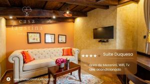 a living room with a couch and a tv at Casa Faustina Boutique Hotel in Antigua Guatemala