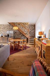 a living room with a table and chairs and a stone wall at Chalet l'Arva in Saint-Marcel