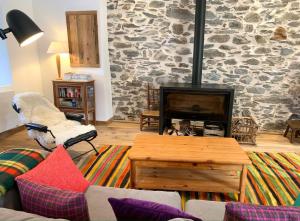 a living room with a stone wall with a fireplace at Chalet l'Arva in Saint-Marcel +34 photos