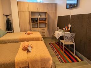 a bedroom with two beds and a table with a chair at Loft de 2 Camas in Callampaya