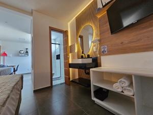 a bathroom with a sink and a vanity with a mirror at Águas de Canto Grande in Bombinhas