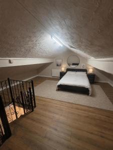 a bedroom with a bed and a staircase in a attic at Northenden Stopsss in Manchester