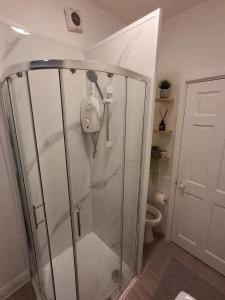 a shower stall in a bathroom with a toilet at Northenden Stopsss in Manchester