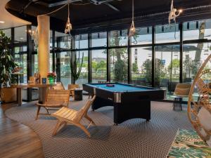 a billiard room with a pool table and chairs at ibis budget Rouen Centre Rive Gauche in Rouen