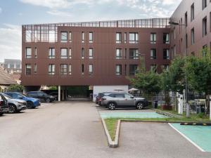 a building with cars parked in a parking lot at ibis budget Rouen Centre Rive Gauche in Rouen
