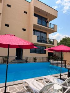 a hotel with a swimming pool with two umbrellas at Horizont Boutique Hotel in Telavi
