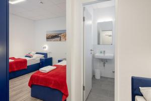 a bathroom with two beds and a sink in a room at E&B Monteurzimmer in Ganderkesee