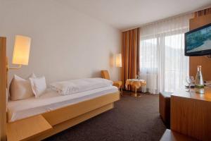 a hotel room with a bed and a television at E&B Monteurzimmer in Ganderkesee