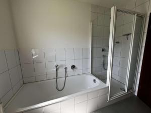 a bathroom with a bath tub and a shower at E&B Monteurzimmer in Ganderkesee