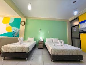 two beds in a room with green walls at Riti Wasi in Yungay