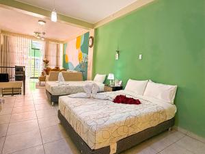 a bedroom with two beds and a green wall at Riti Wasi in Yungay