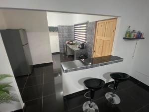 a kitchen with a counter and two stools in it at Casa playa el Retén 