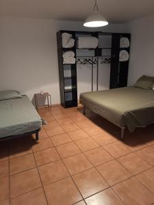 a bedroom with two beds and a tiled floor at F1 plain-pied in Montjaux