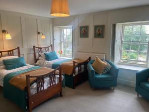 a room with two beds and a table and chairs at Tor Royal Farm House in Princetown