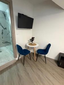ein Tisch und zwei Stühle und ein Tisch und ein Fernseher in der Unterkunft hidden modern studio in Vathý
