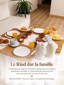 a table with plates of food and pitchers of orange juice at Dar la famille Marrakech in Marrakesh +24 photos