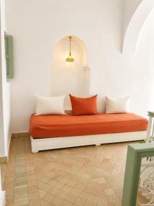 a bed with three pillows on it in a room at Dar la famille Marrakech in Marrakesh