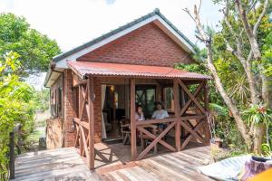 two people sitting at a table in a small house at 今帰仁森風テラス in Nakijin