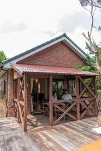 two people sitting at a table outside of a building at 今帰仁森風テラス in Nakijin +6 photos