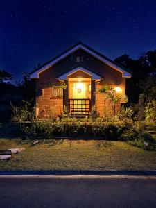 a house with a light in the window at night at 今帰仁森風テラス in Nakijin