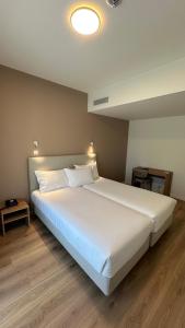a bedroom with a large white bed in a room at Hotel João Paulo II in Braga +32 photos