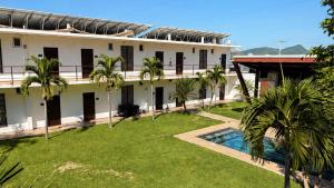 an exterior view of a building with a swimming pool at Hotel y Jardín Las Asadas, Bar y Grill in Xochitepec