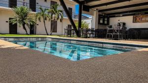 a swimming pool in front of a building at Hotel y Jardín Las Asadas, Bar y Grill in Xochitepec