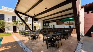 a patio with tables and chairs and a bar at Hotel y Jardín Las Asadas, Bar y Grill in Xochitepec +11 photos