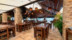 a restaurant with wooden tables and chairs in it at Hotel y Jardín Las Asadas, Bar y Grill in Xochitepec