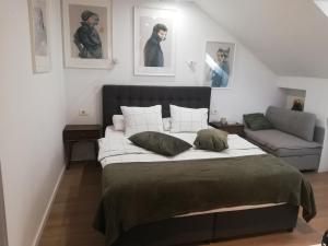 a bedroom with a large bed and a couch at Apartments Simple Teslina in Zagreb