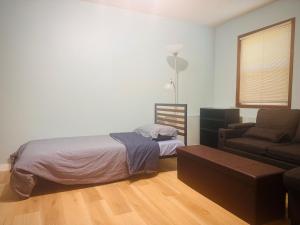 a bedroom with a bed and a couch and a chair at Zoe house in Victoria