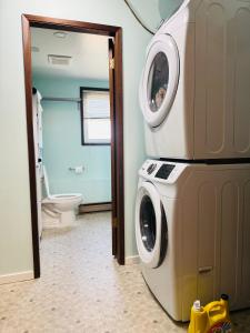 a washer and dryer in a bathroom with a toilet at Zoe house in Victoria