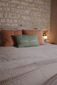 a bed with a pillow on top of it at Maisons Vaudésir - Lyla, Chablis in Chablis