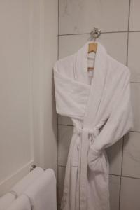 a white robe hanging on a rack in a bathroom at Maisons Vaudésir - Lyla, Chablis in Chablis +26 photos