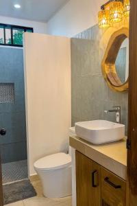 ein Badezimmer mit Waschbecken, Toilette und Dusche in der Unterkunft Vidal in Popoyo