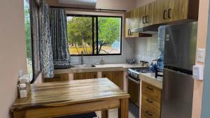 eine kleine Küche mit einem Holztisch und einem Fenster in der Unterkunft Vidal in Popoyo