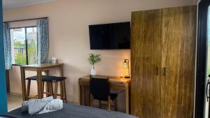 ein Schlafzimmer mit Schreibtisch, Bett und Holzschrank in der Unterkunft Vidal in Popoyo