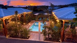 Draufsicht auf ein Haus mit beleuchtetem Swimmingpool in der Unterkunft Vidal in Popoyo