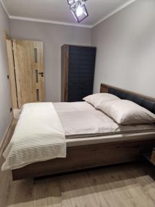 a bedroom with a large bed with a wooden headboard at Lubanska by Tauron Arena in Zgorzelec